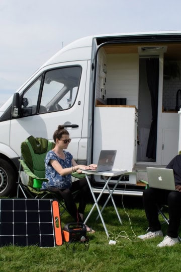 working on laptops in front of van