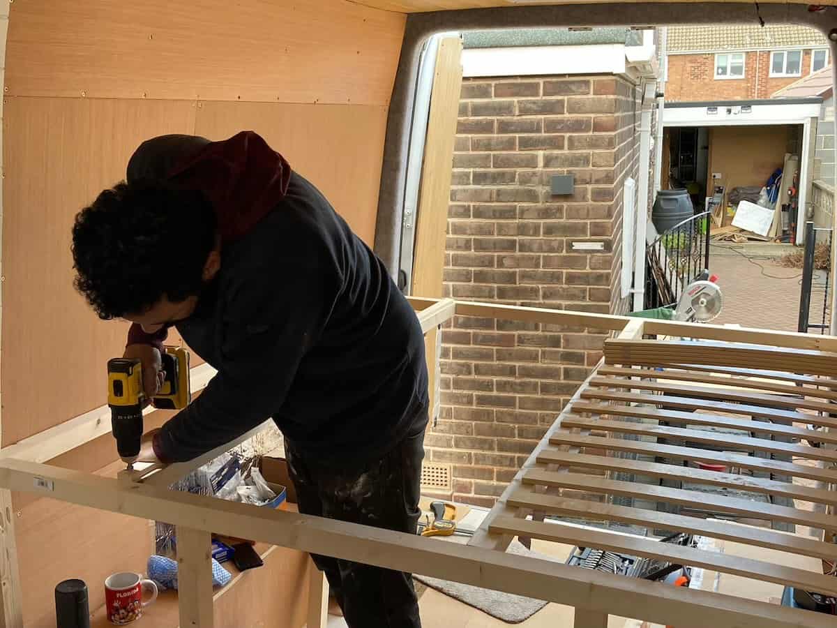 Man building a bed in a campervan
