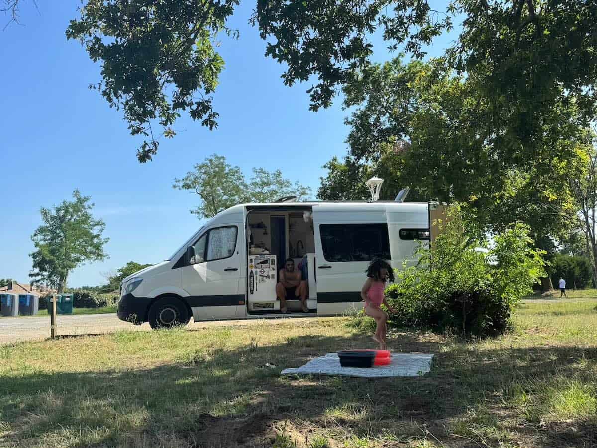 Campervan parked up with child playing in front